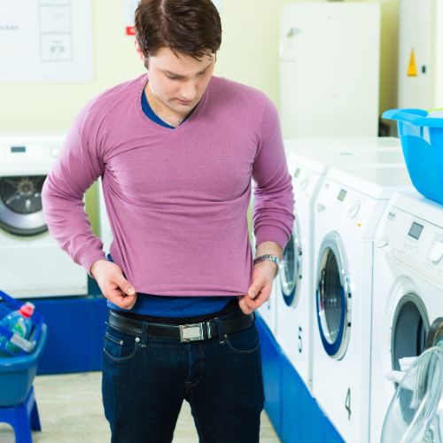 man wearing shrunk clothing from steam dryer